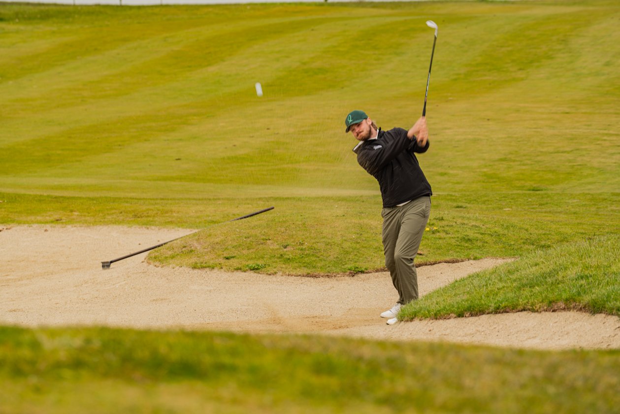Golfspieler beim Schlag aus dem Bunker
